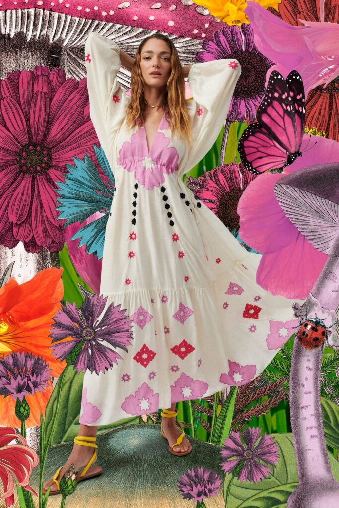 A relaxed white dress with long sleeves, a V-neckline, and a tiered floral design.