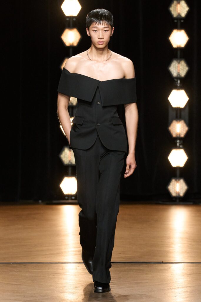 A fitted black jacket with structured design paired with matching pants.