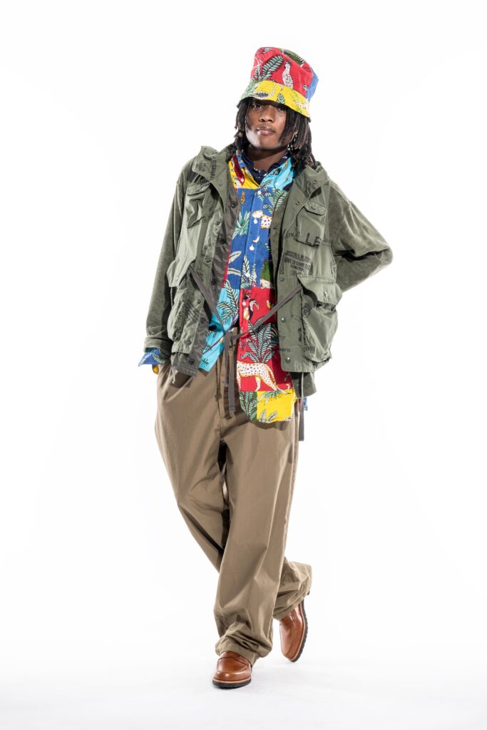 A relaxed green jacket paired with multicolored printed pants for a vibrant streetwear look.