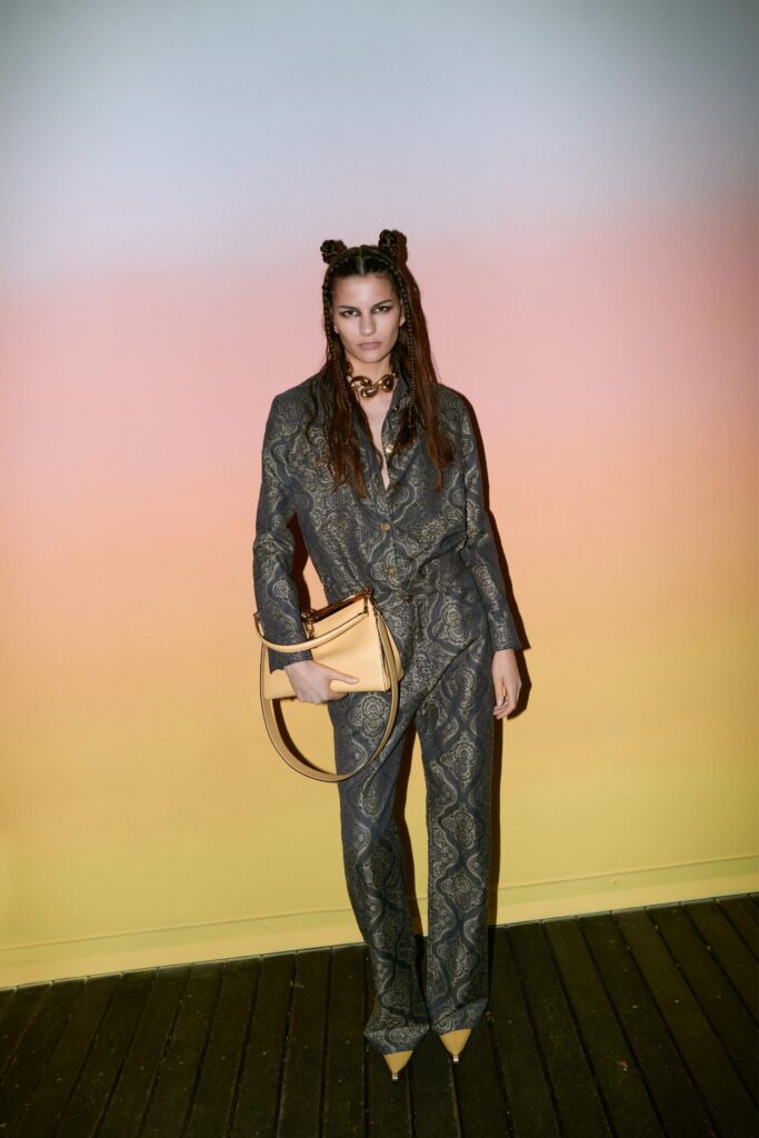 A fitted gray silk jumpsuit with long sleeves and a collared neckline featuring a printed design.