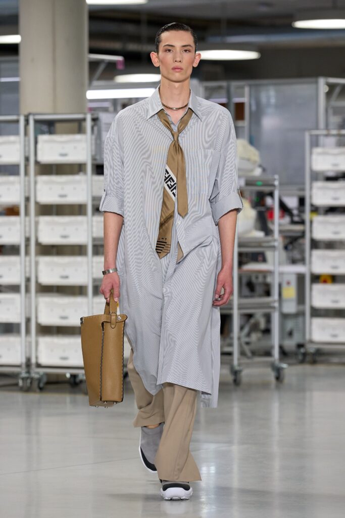 A relaxed gray striped shirt-dress paired with beige pants, featuring a collared neckline.