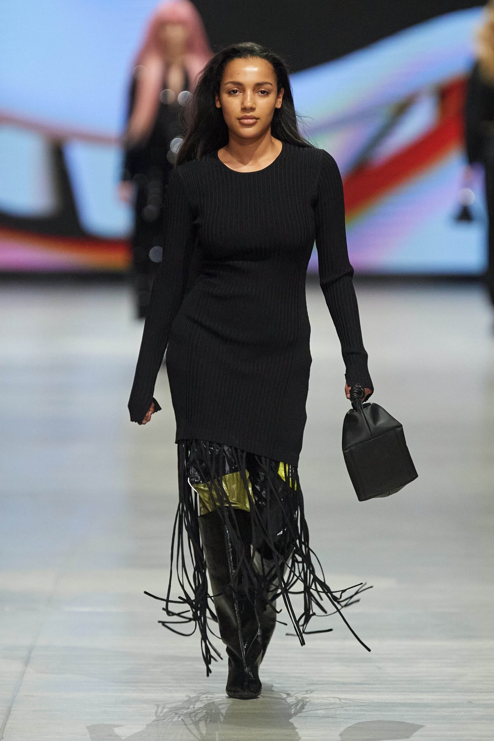 A fitted black knit dress with long sleeves, high neckline, and fringed detailing.