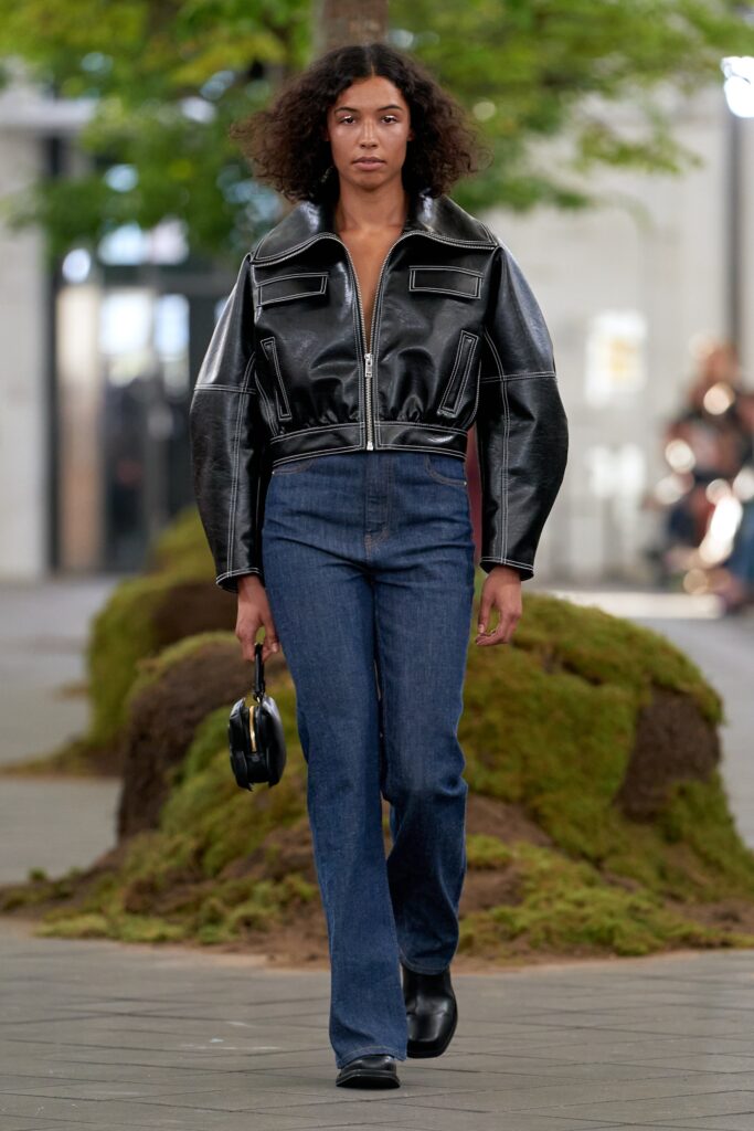 black leather fitted jacket and blue denim pants