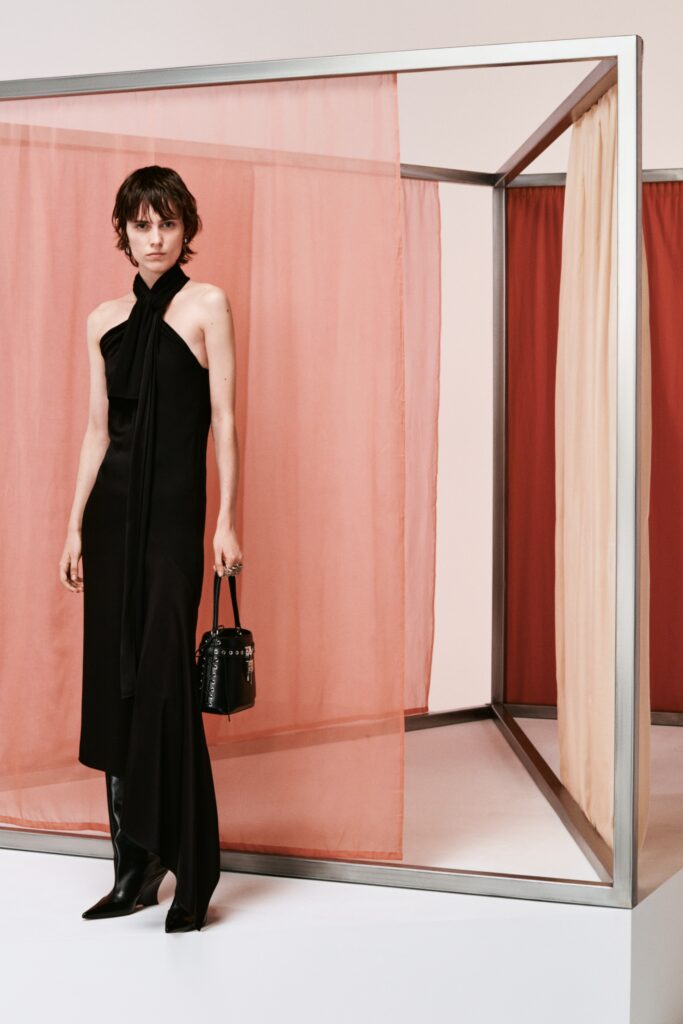A fitted black silk dress with a sleeveless design and asymmetric silhouette.