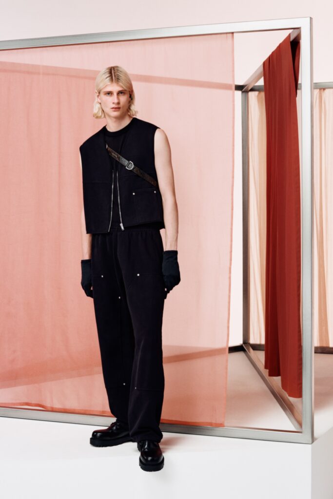 A relaxed black sleeveless top paired with high-waisted pants featuring an asymmetric design.