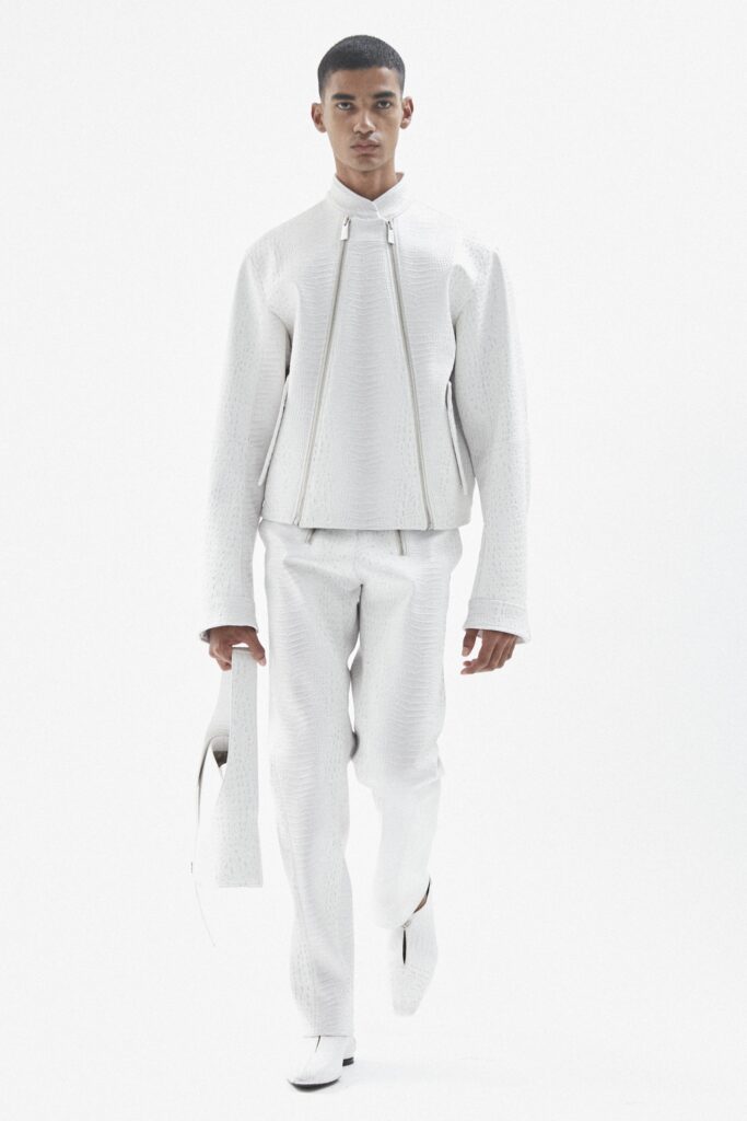A fitted white leather jacket with long sleeves and a collared design, paired with matching pants.