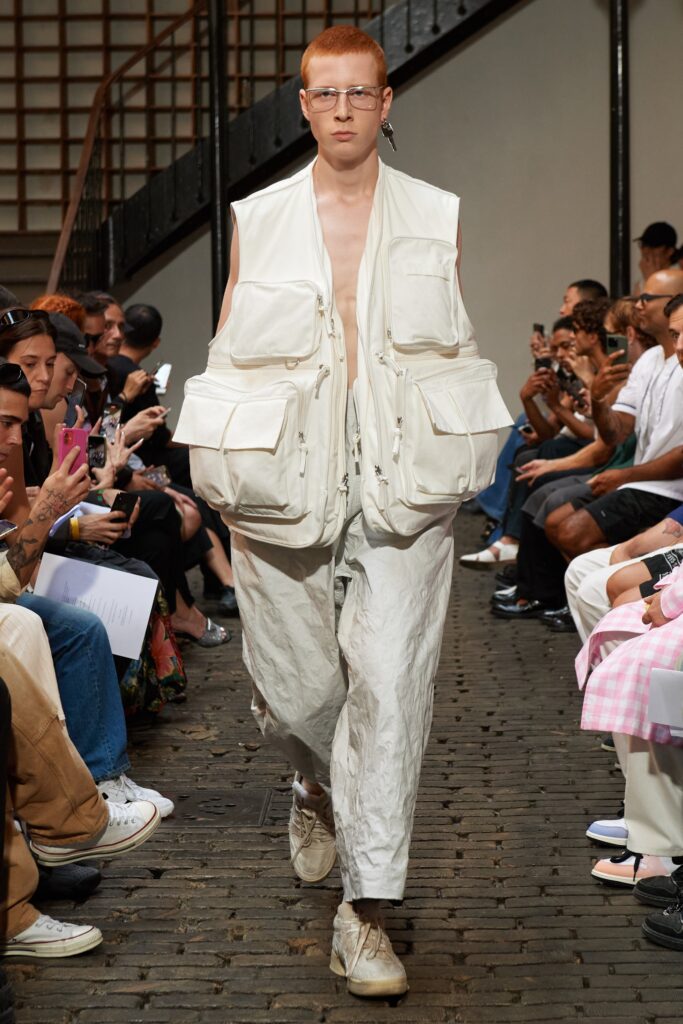 A relaxed white sleeveless vest paired with matching pants featuring zippered details.