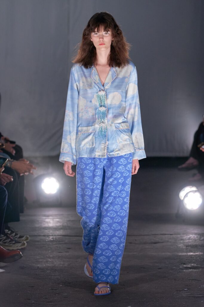 A relaxed blue silk long-sleeve shirt with a collar paired with printed pants.