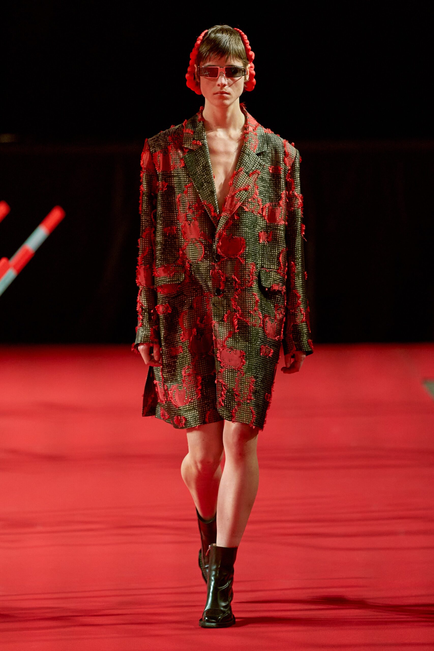 An oversized black and red blazer dress with long sleeves and an embroidered asymmetric design.