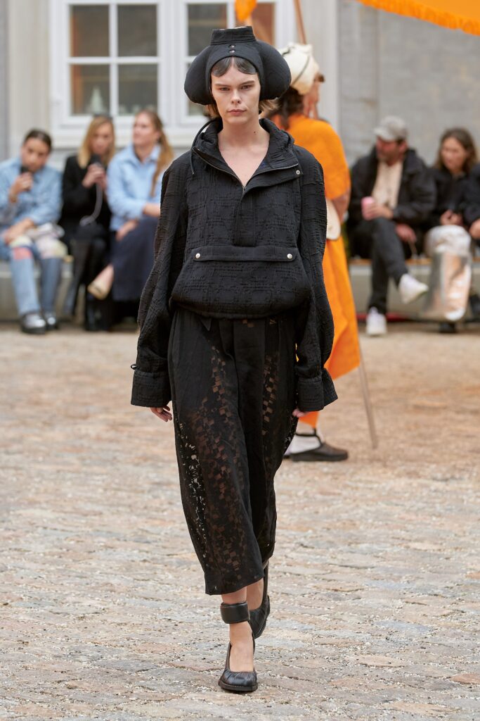 A relaxed black cotton jacket with long sleeves and matching pants featuring a layered design.