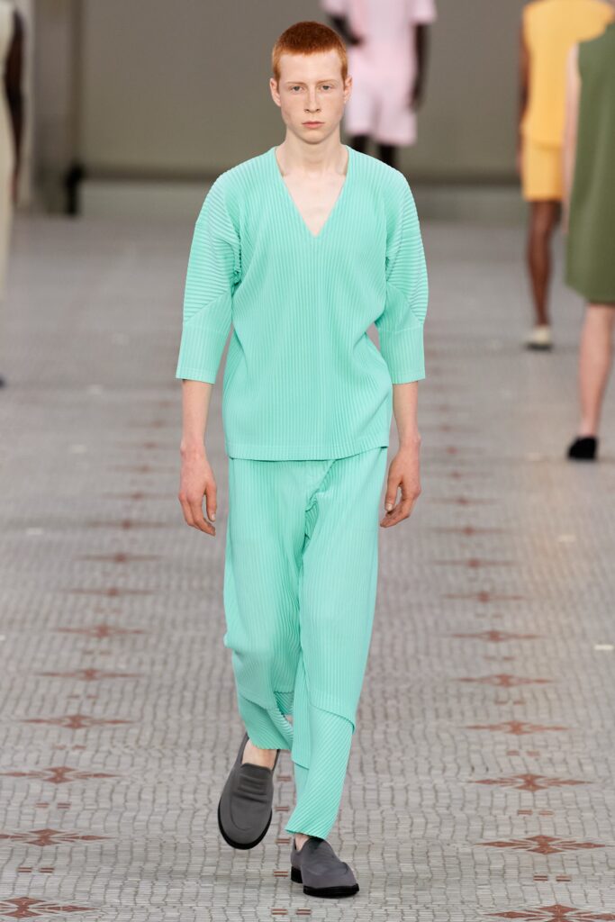 A relaxed-fit green cotton shirt with a V-neck and pleated design, paired with matching pants.
