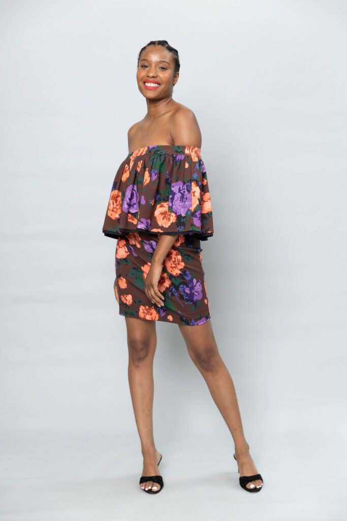 This fitted dress showcases a vibrant floral pattern that brings a lively touch to the silhouette. The off-shoulder design adds a playful element, while the flared hem creates movement, making it an eye-catching choice for any occasion.