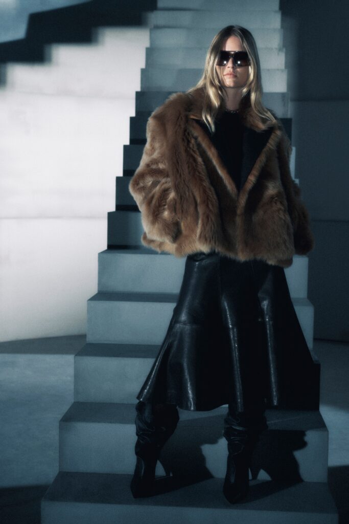 A fitted brown fur coat paired with a flared black leather skirt.