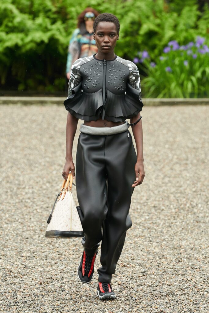 A fitted black leather top with short sleeves and ruffled detail, paired with matching pants.