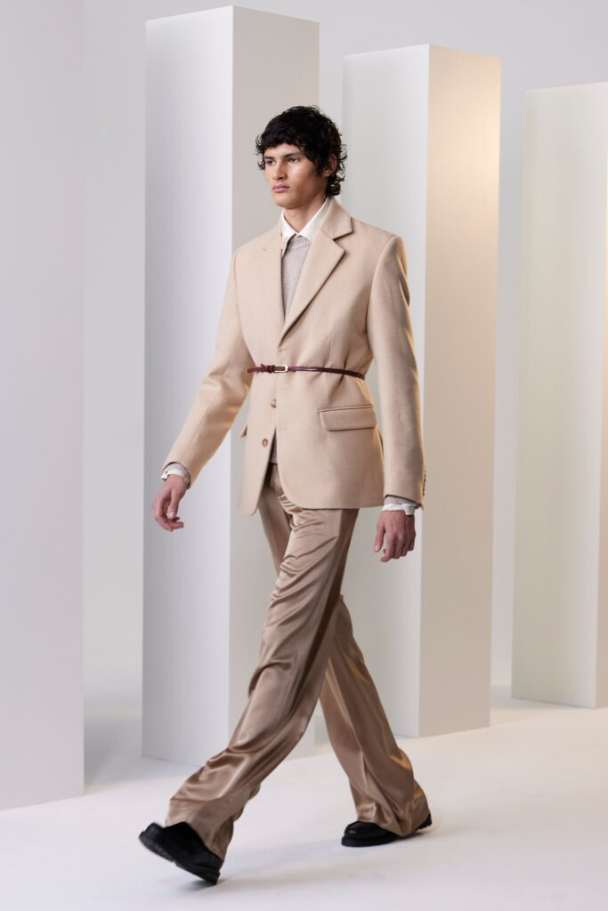 A tailored beige blazer with long sleeves and collared neck paired with straight-leg pants.