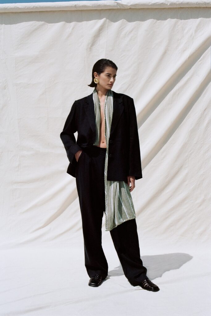 A relaxed black jacket with long sleeves and a collared design paired with matching pants.