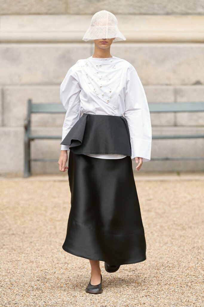 A relaxed black and white top with long sleeves and an asymmetric layered skirt.