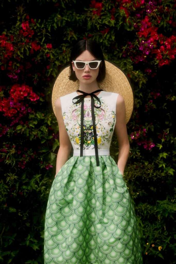 A fitted green and white floral dress with a high neckline and flared silhouette.