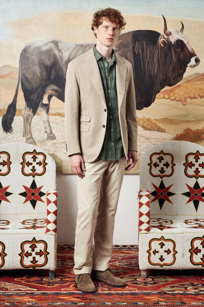A tailored beige suit with a collared long-sleeve shirt and buttoned details.