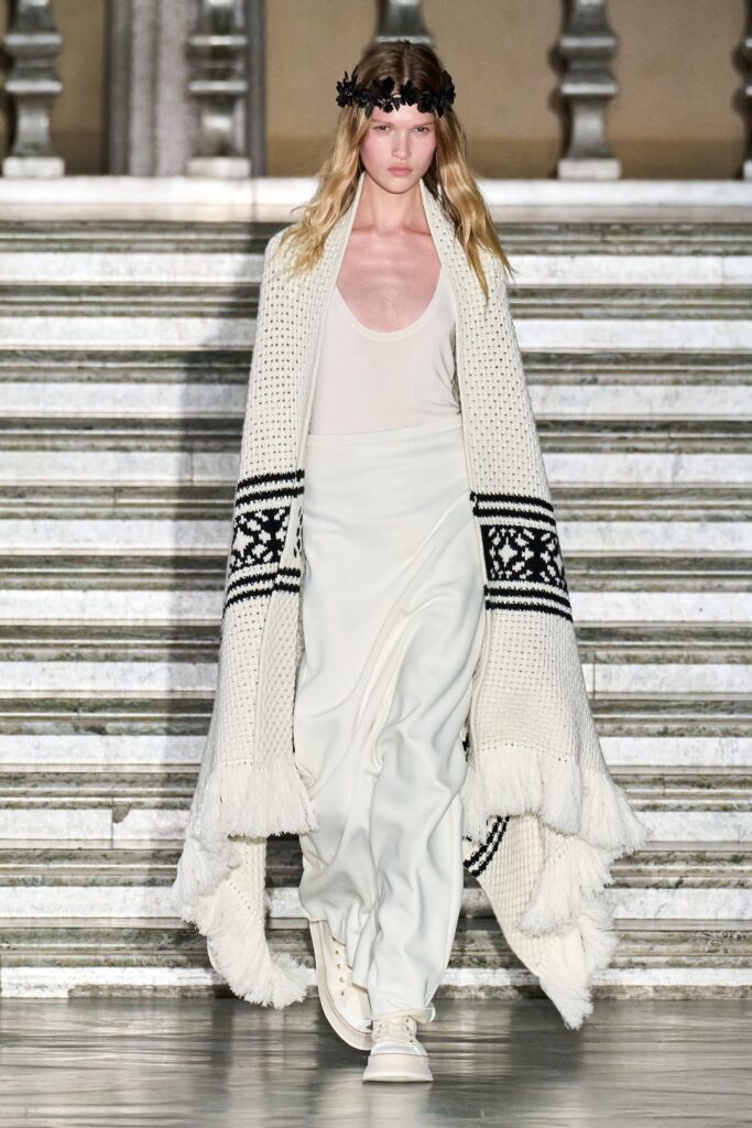 A relaxed white sleeveless dress layered with a decorative coat, perfect for a stylish look.
