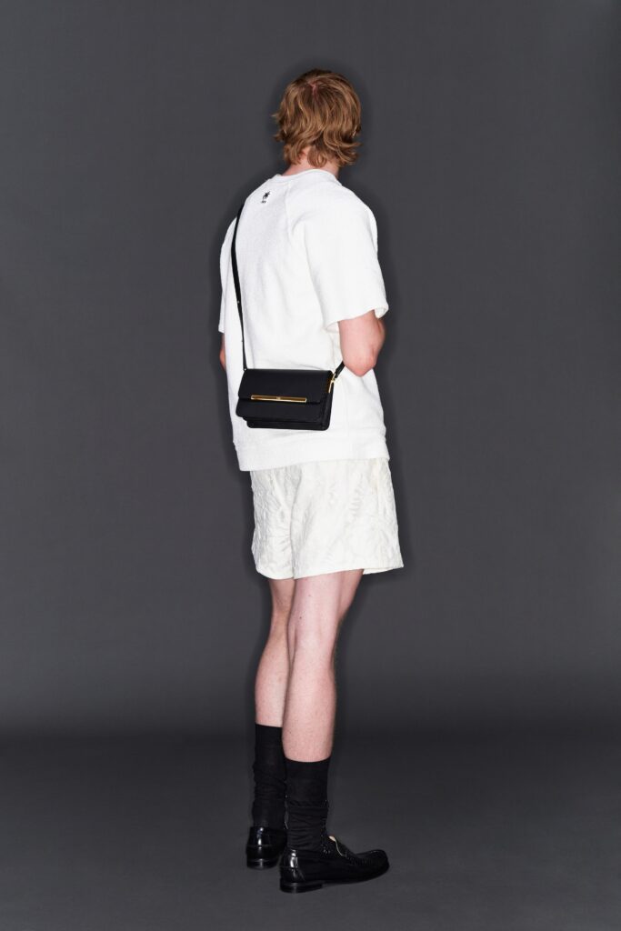 A relaxed white short-sleeve collared shirt paired with plain shorts.