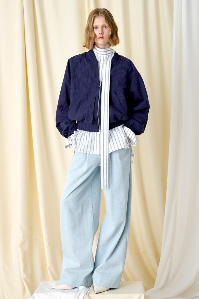 A relaxed blue cotton jacket with a collared long-sleeve shirt and wide-leg denim pants.