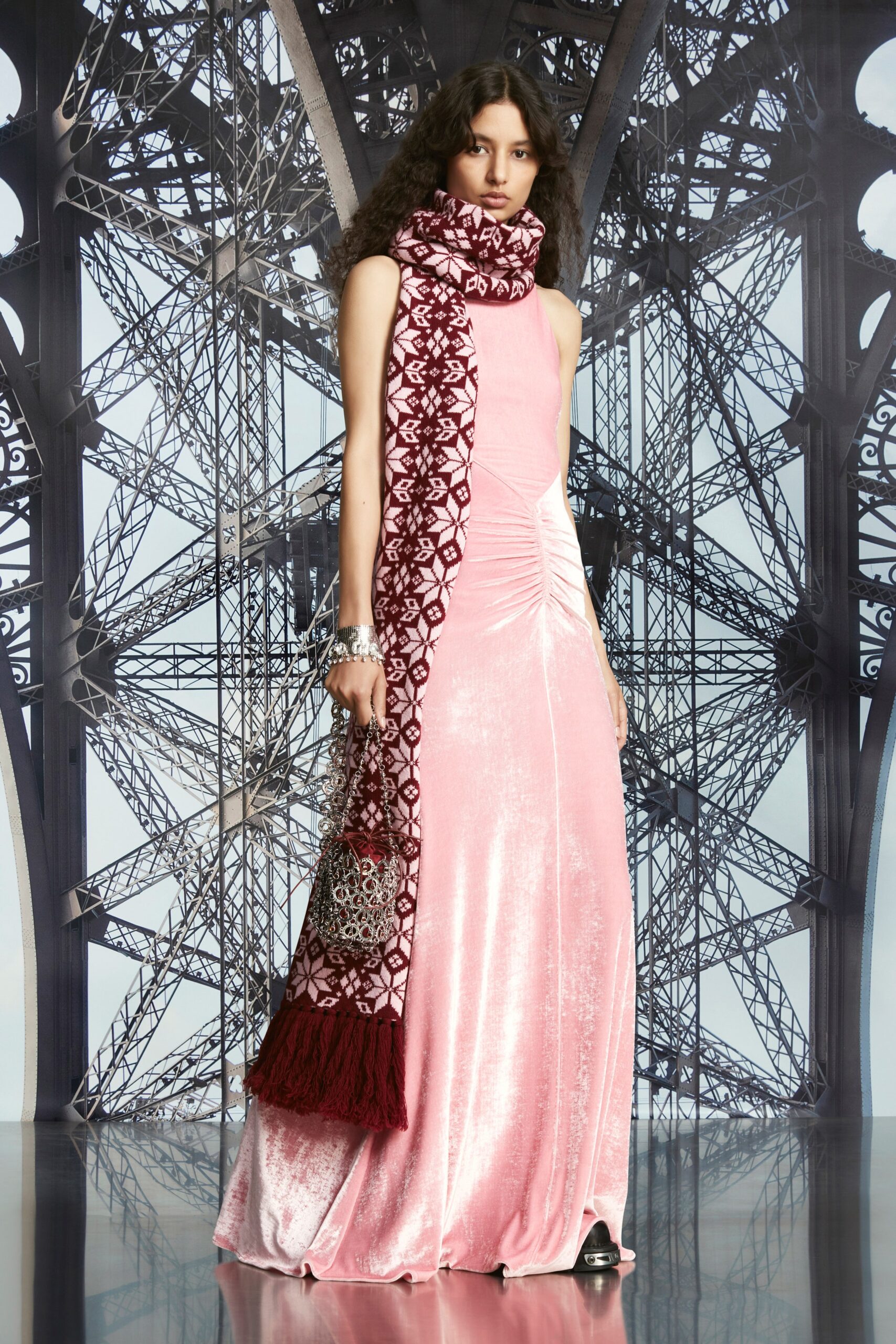 A fitted pink velvet dress with a high neckline and ruched detailing.