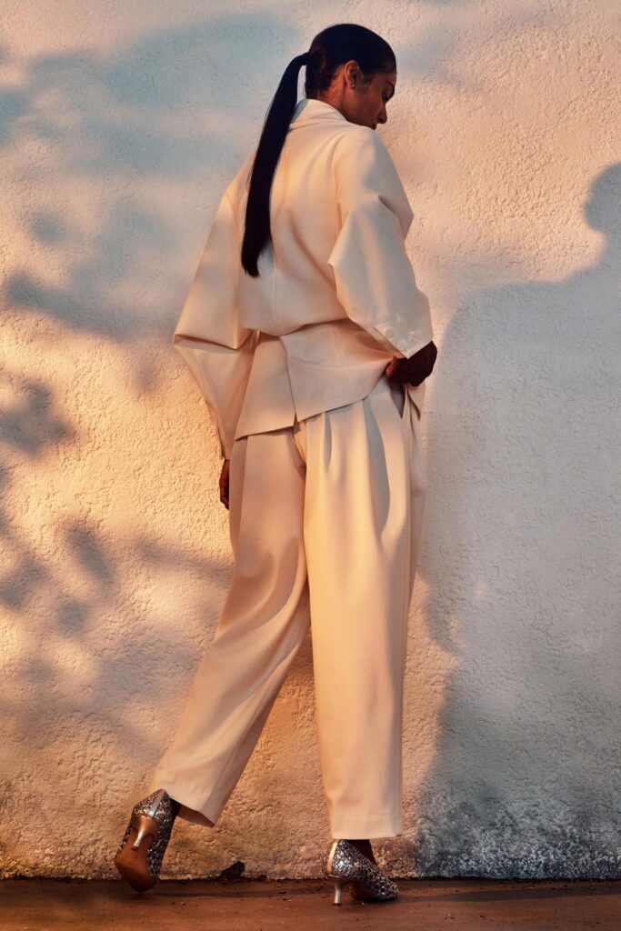 A relaxed beige silk jacket with long sleeves and asymmetric design paired with matching pants.