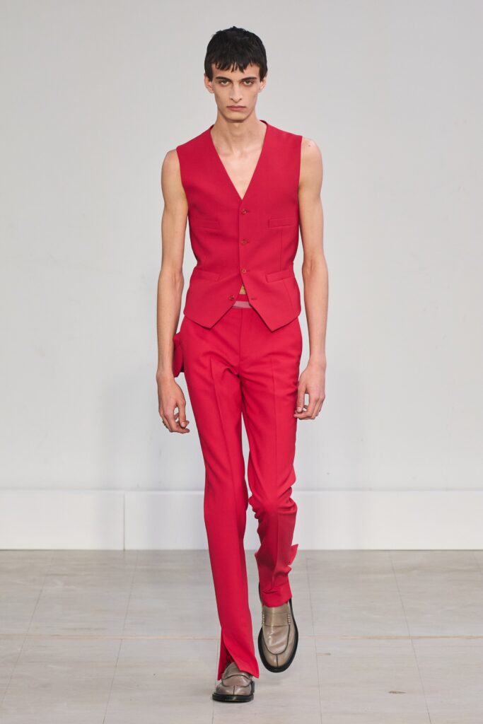 A fitted red sleeveless vest paired with straight-leg pants for a modern look.