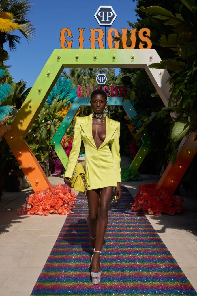 A fitted yellow silk dress with a V-neckline and asymmetric design details.