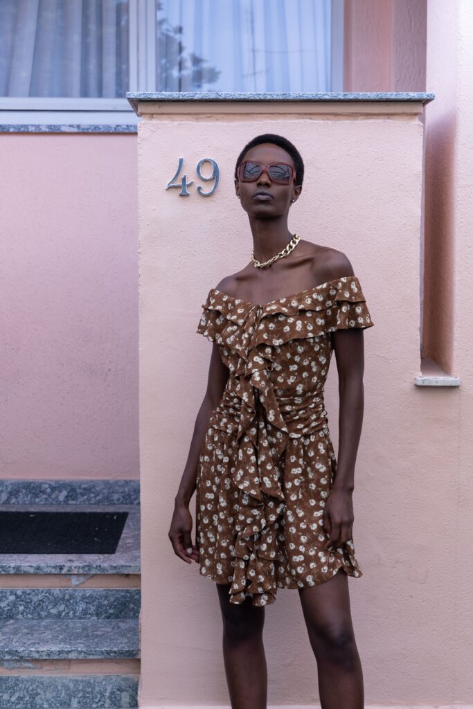 A fitted brown cotton off-shoulder dress with ruffled details and a flared silhouette.