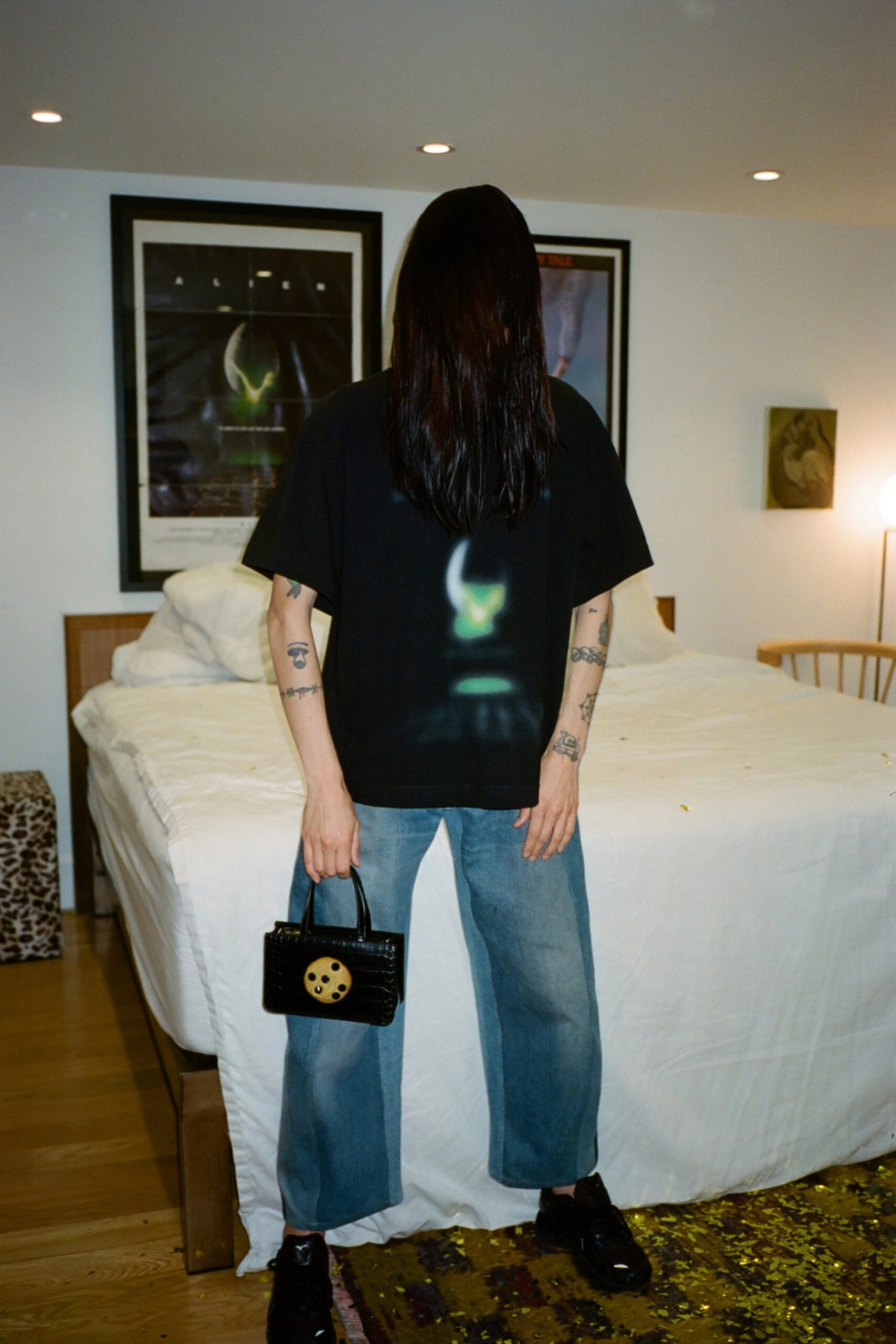 A relaxed black t-shirt with short sleeves paired with straight-leg blue denim pants.