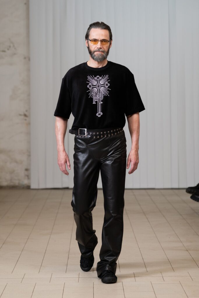A fitted black cotton top with short sleeves paired with black leather pants.