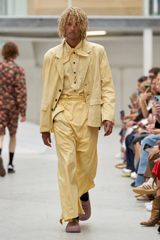A relaxed yellow cotton suit with a collared long-sleeve shirt and wide-leg trousers.