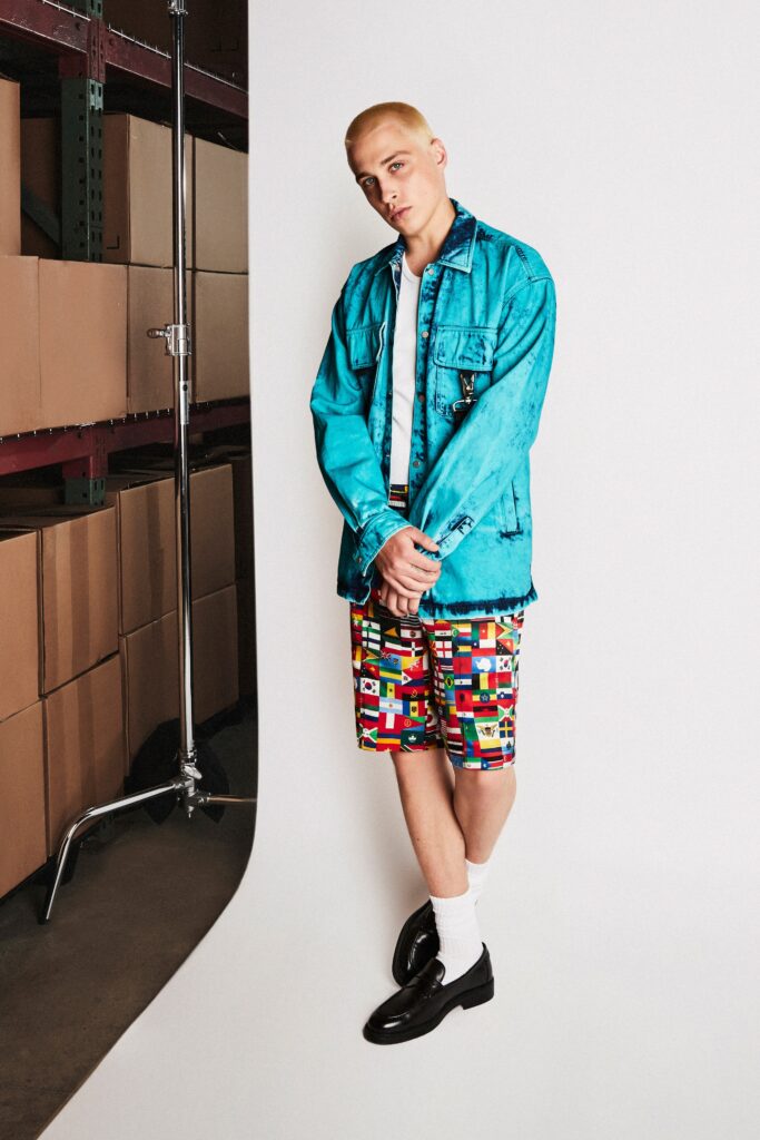 A relaxed blue denim jacket paired with high-waisted printed shorts for a vibrant look.