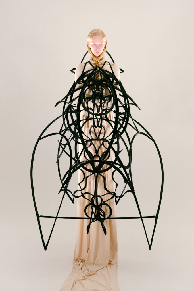 An asymmetric layered beige silk dress featuring intricate design elements and a unique silhouette.