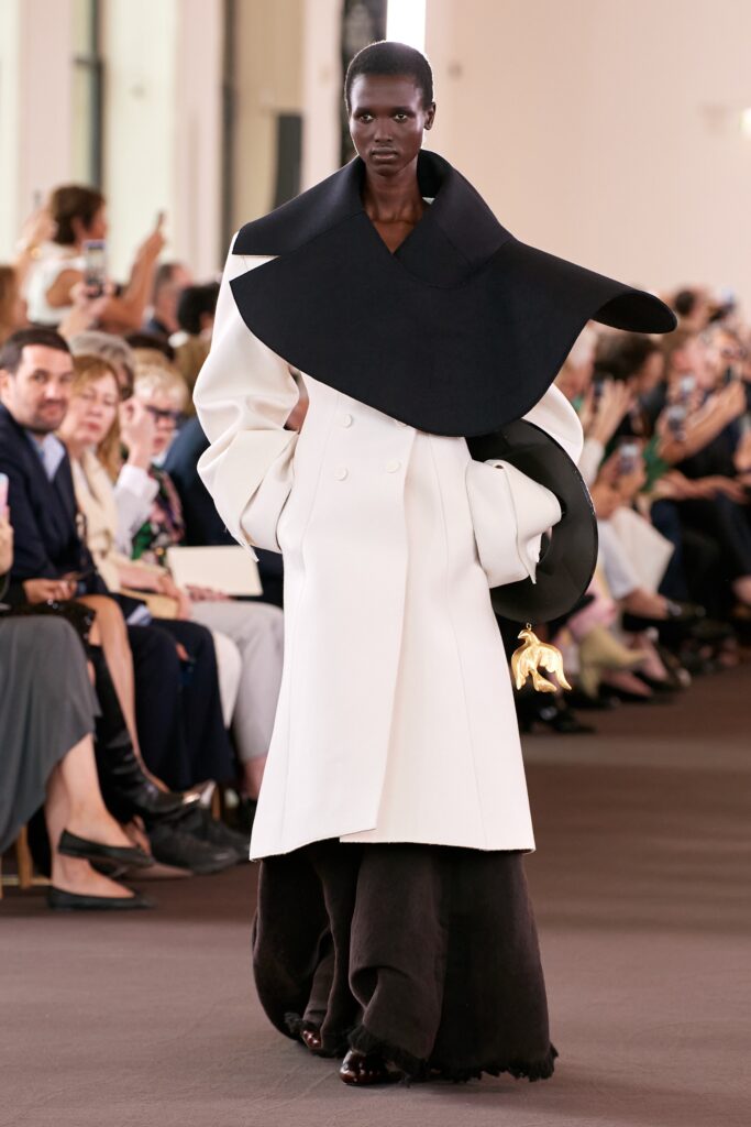 An oversized black and white coat with long sleeves and an asymmetric collar design.