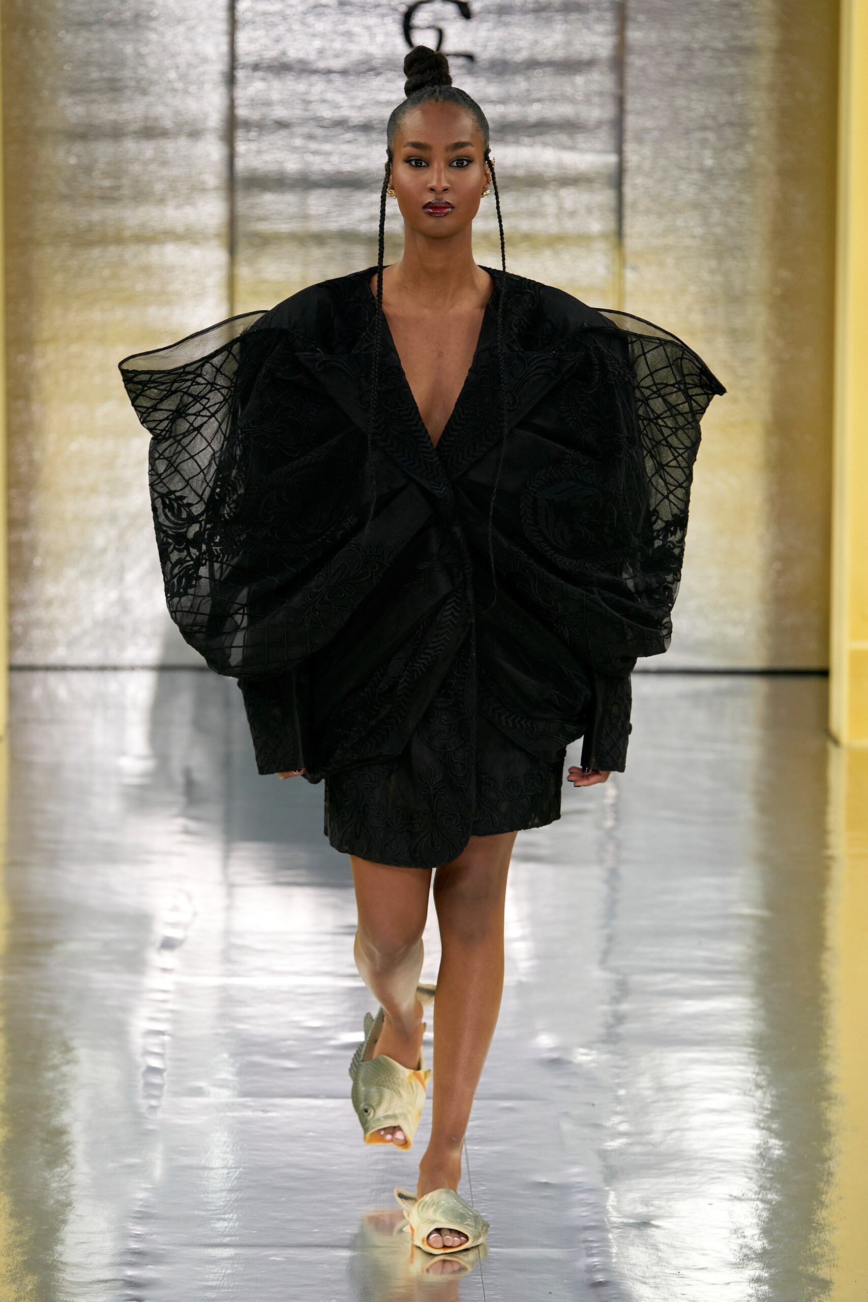 A fitted black silk dress with a V-neckline and asymmetric design details.