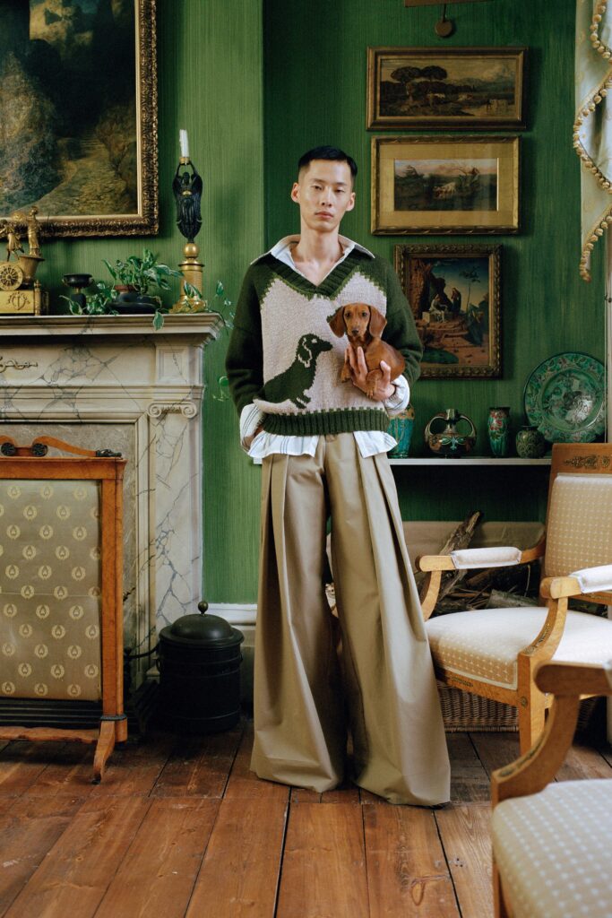 A relaxed green printed sweater with a collared neckline paired with wide-leg beige pants.