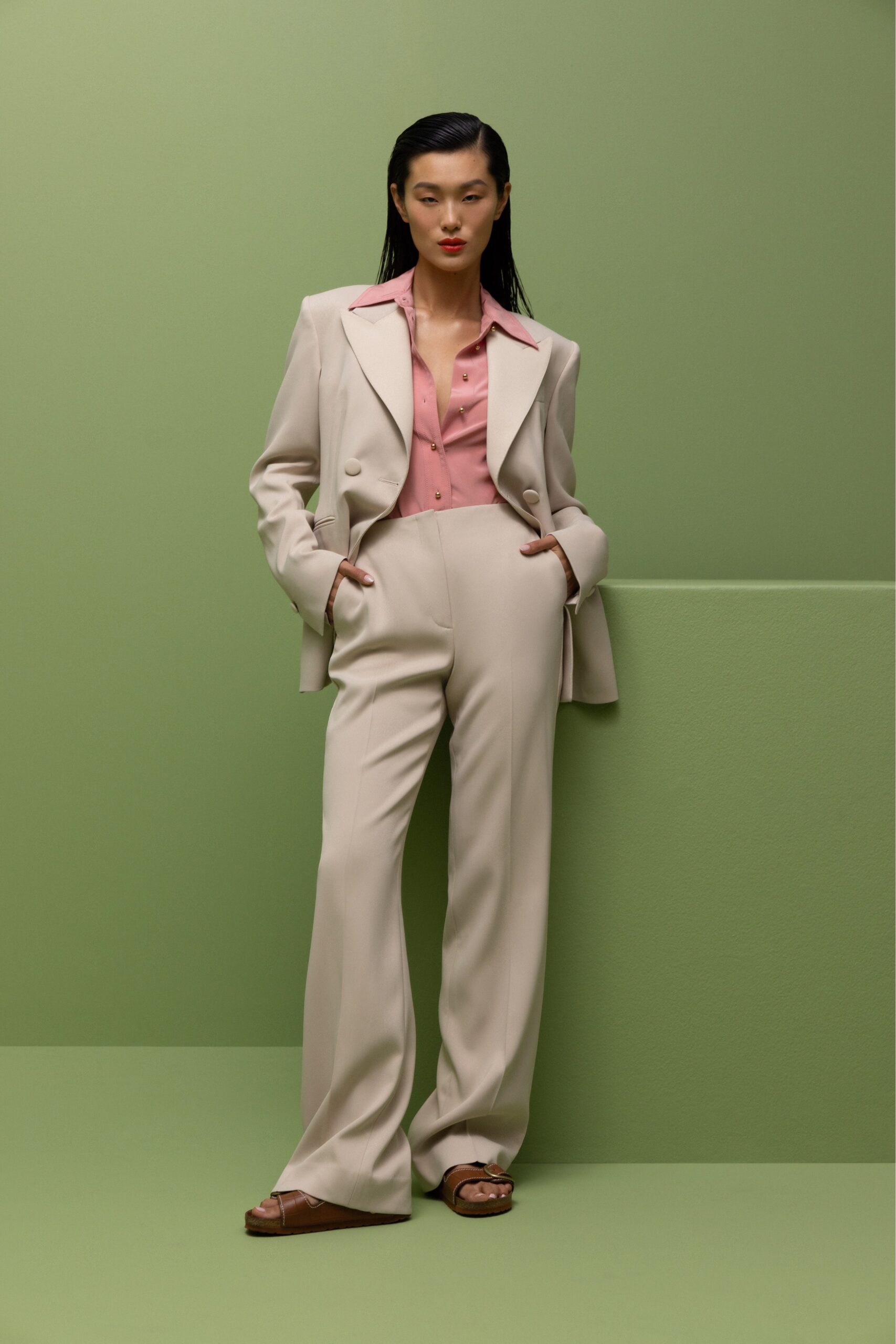 A relaxed beige blazer paired with pink collared shirt and straight-leg pants.