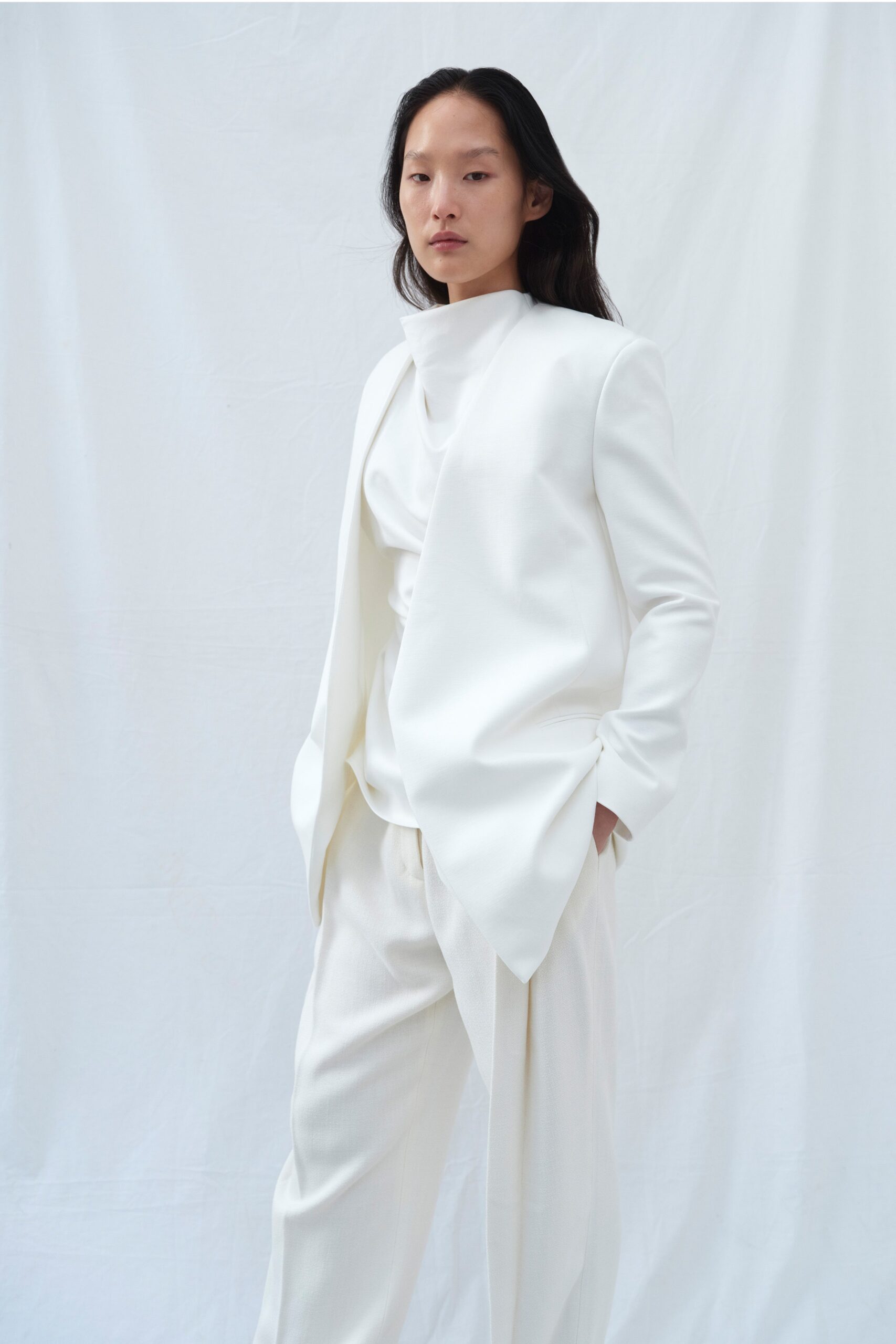 A relaxed white suit featuring a long-sleeve collared top and straight-leg trousers.