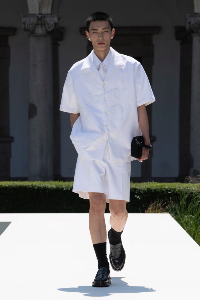 A relaxed white short-sleeve collared shirt paired with matching shorts, featuring a buttoned design.