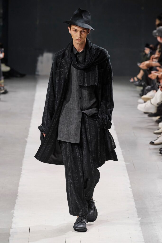 A relaxed black coat paired with matching pants, featuring a layered design.