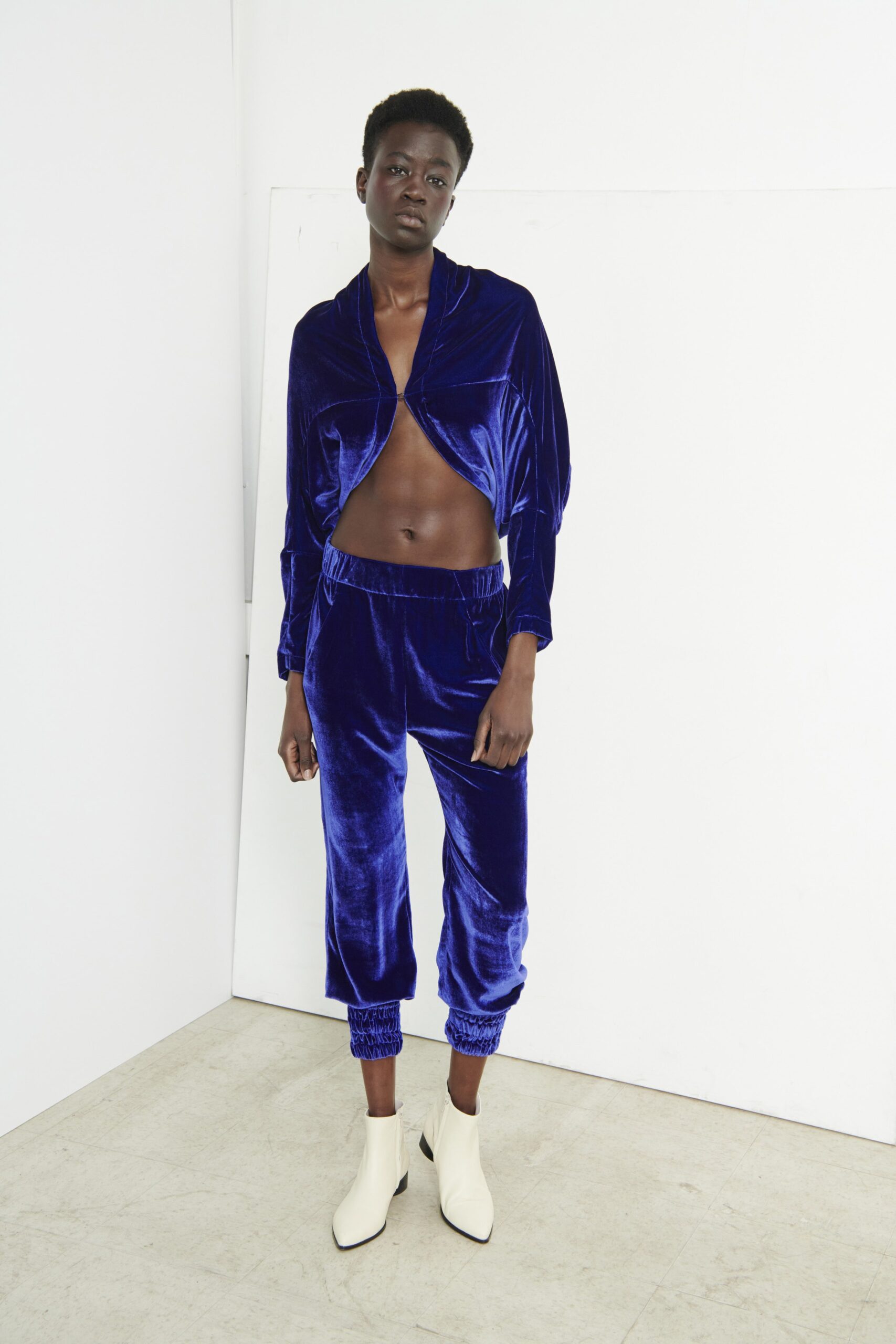 A fitted blue velvet long-sleeve top paired with matching pants, featuring a cropped design.