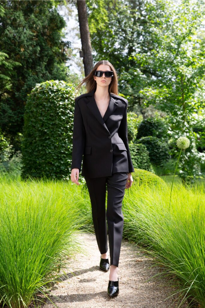 A tailored black suit with a collared long-sleeve jacket and straight-leg trousers.