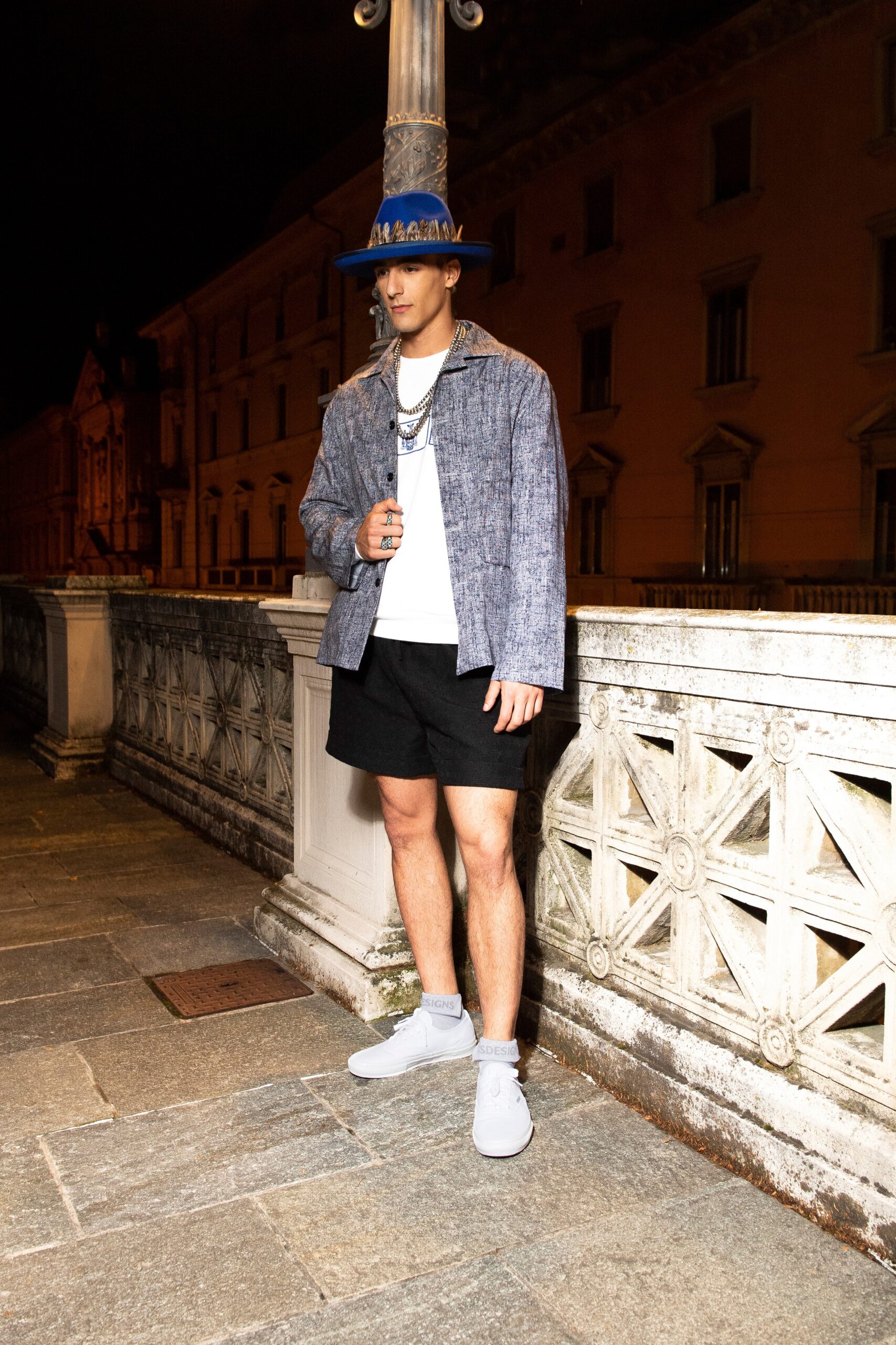 A relaxed blue cotton jacket with short sleeves paired with black shorts.