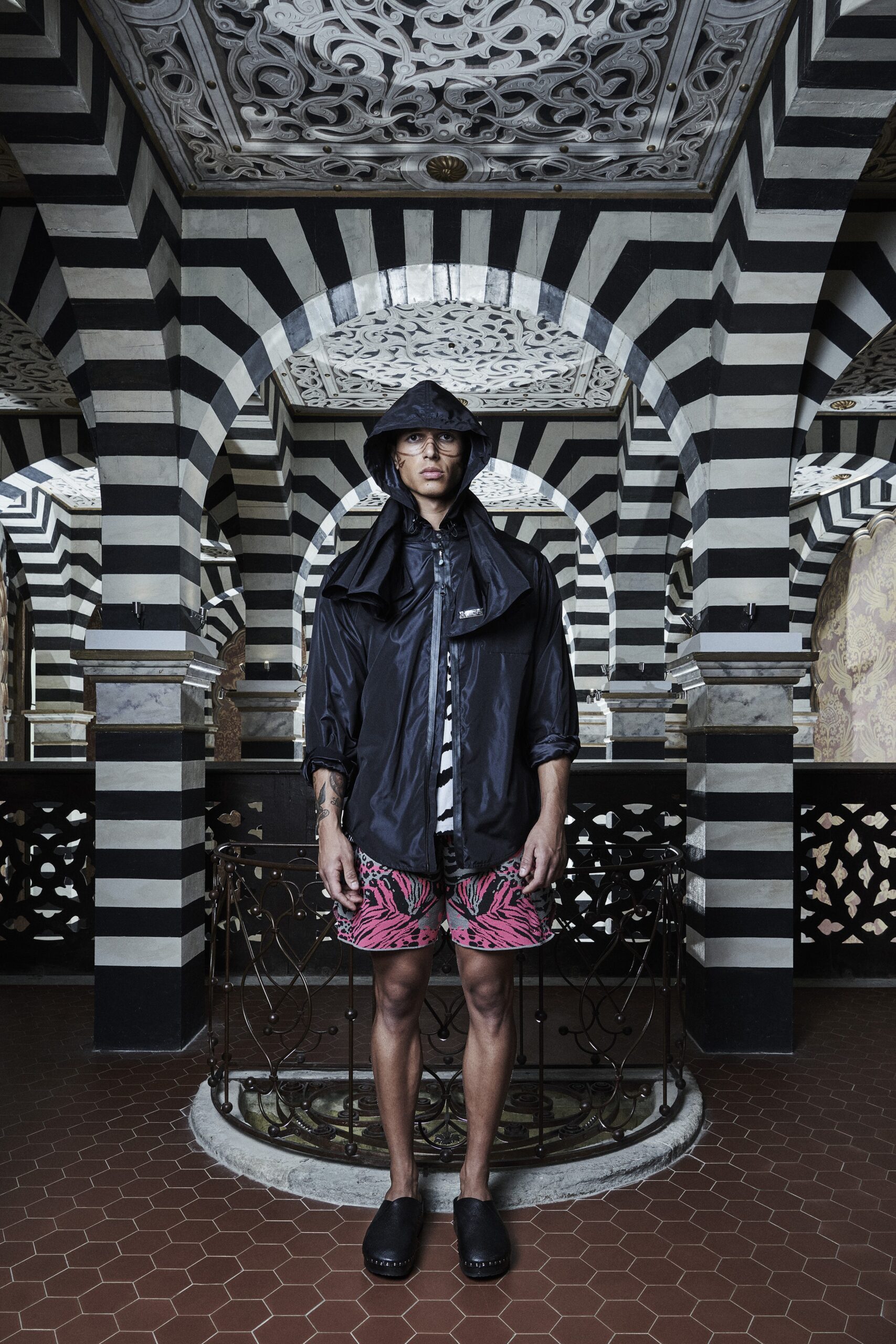 A relaxed black jacket paired with printed pink shorts, featuring a collared design.