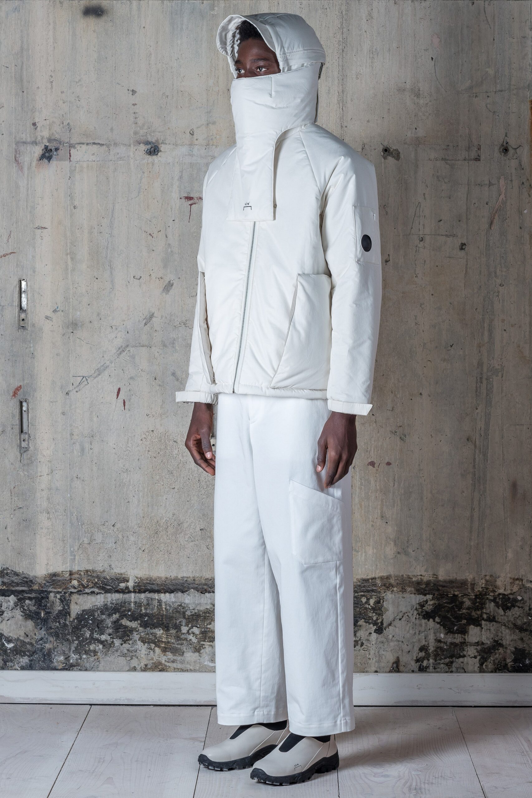 A relaxed white hooded jacket paired with matching pants, featuring a zippered front.