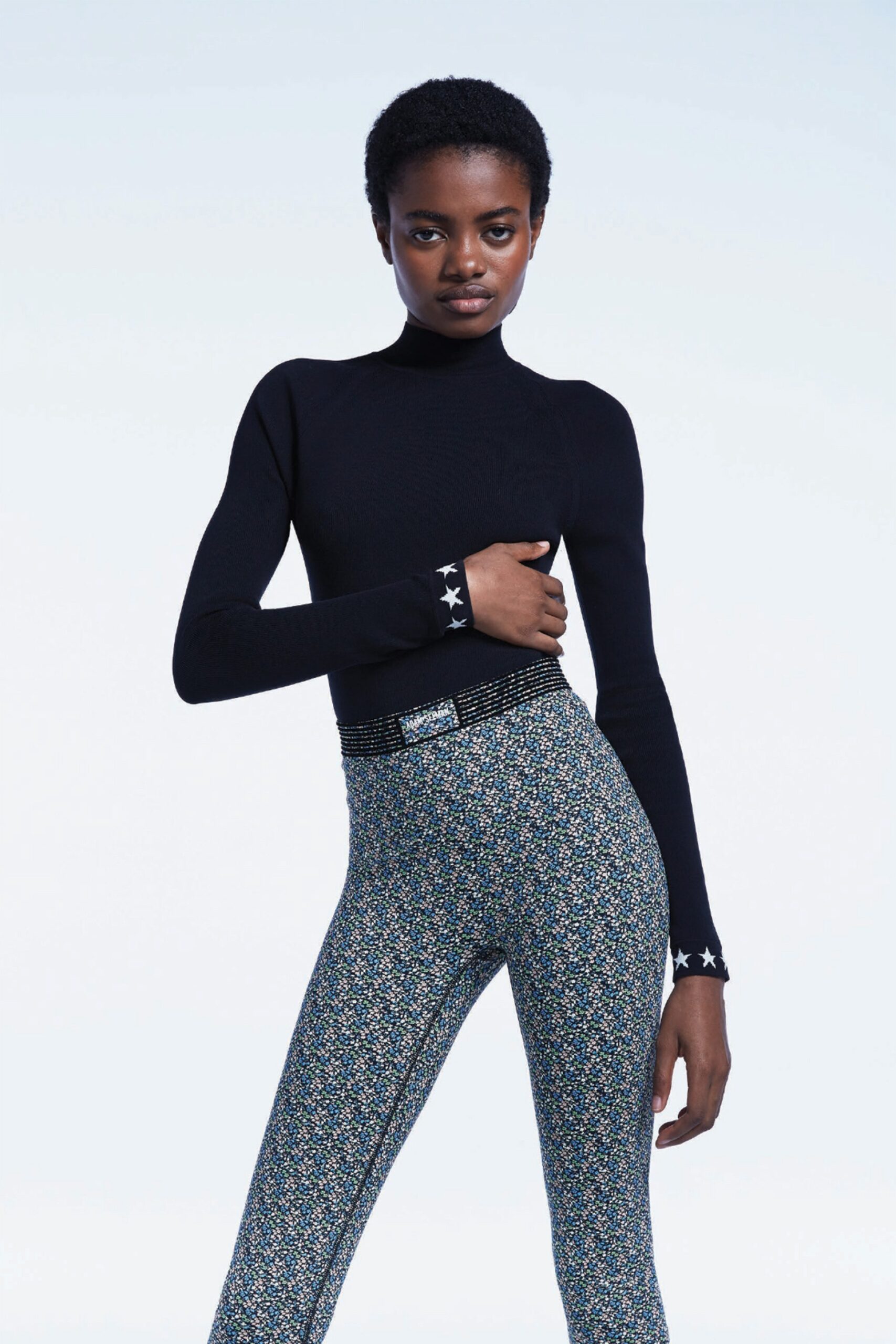 black fitted turtleneck and multi flared pants