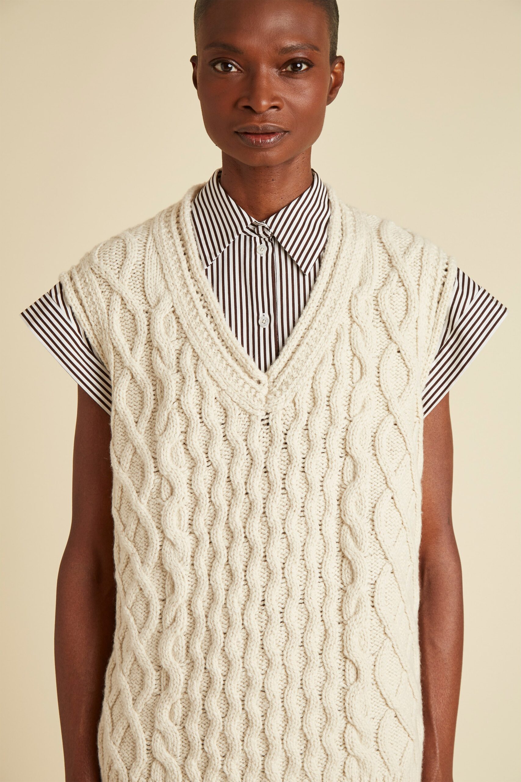 white knitted sleeveless sweater and striped shirt